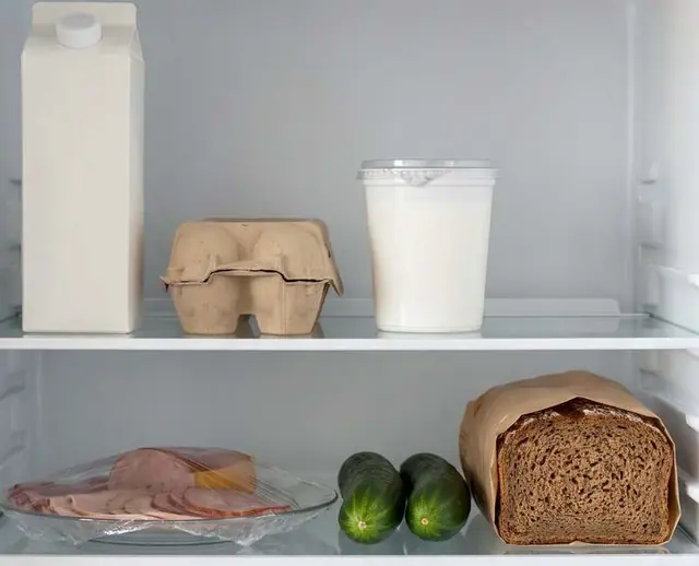 Das Innere eines Kühlschranks: Milch, Eier, Joghurt, Schinken, Gurken und Brot