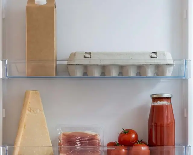 L’interno di un frigo: latte, uova, parmigiano, prosciutto, pomodori e passata