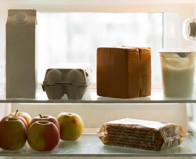 Innsiden av et kjøleskap: melk, egg, epler, knekkebrød og yoghurt