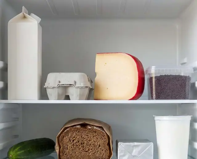 De binnenkant van een koelkast: melk, eieren, kaas, yoghurt, komkommer en brood